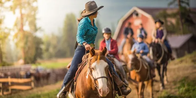 A wrangler leading out a group ride at Three Bars Ranch in Canada.